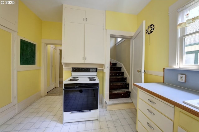 kitchen with white cabinetry, light countertops, and white range with electric stovetop