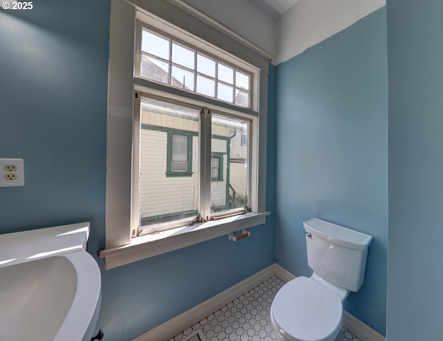 bathroom featuring baseboards and toilet