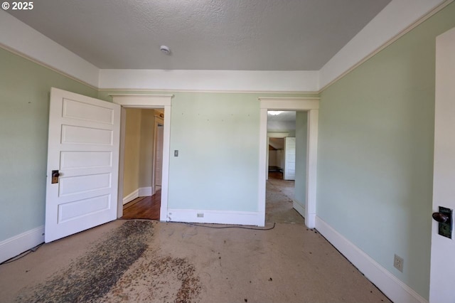 unfurnished bedroom with a textured ceiling and baseboards