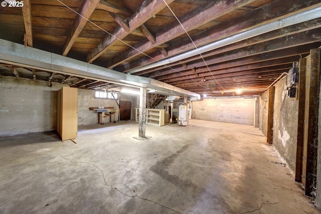 basement with water heater and stairs