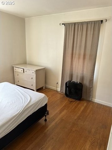 bedroom with light wood finished floors and baseboards