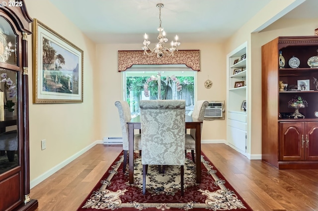 dining room with a chandelier, wood finished floors, an AC wall unit, and a baseboard radiator
