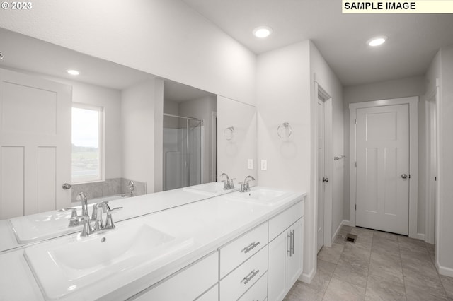 bathroom featuring plus walk in shower, vanity, and tile patterned floors