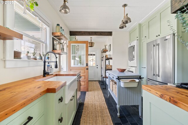 4134 N Concord Ave, Portland, OR 97217 - kitchen featuring wood counters, green cabinets, and stacked washer and dryer