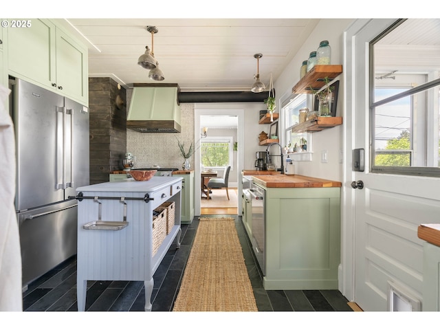 kitchen featuring green cabinetry, butcher block countertops, premium range hood, tasteful backsplash, and high quality fridge