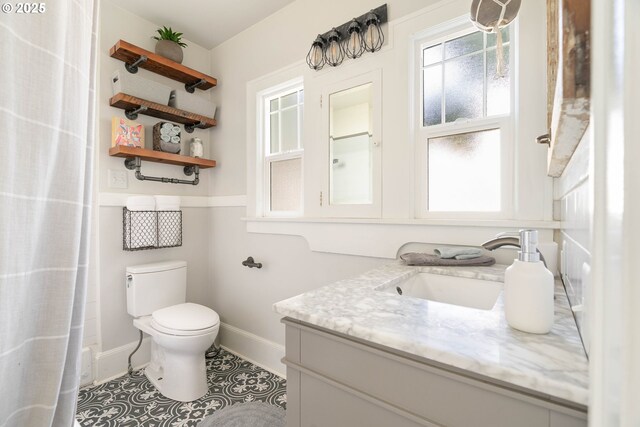 4134 N Concord Ave, Portland, OR 97217 - bathroom with baseboards, tile patterned flooring, toilet, and vanity