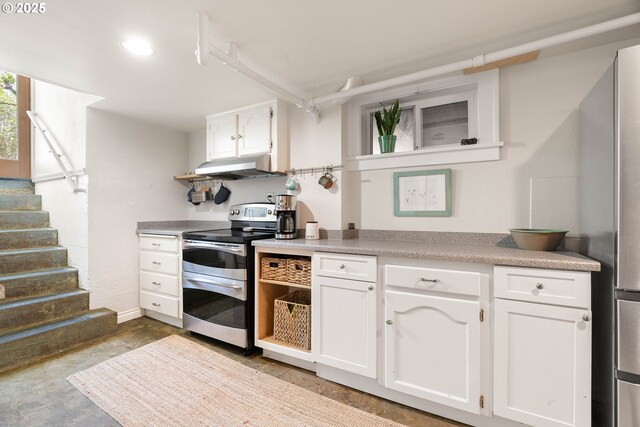 4134 N Concord Ave, Portland, OR 97217 - kitchen featuring white cabinets, concrete flooring, light countertops, range with two ovens, and under cabinet range hood