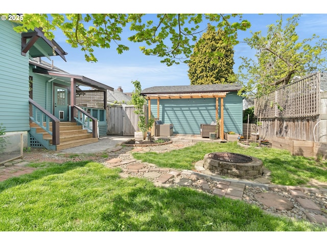 view of yard featuring a fire pit, a fenced backyard, and entry steps