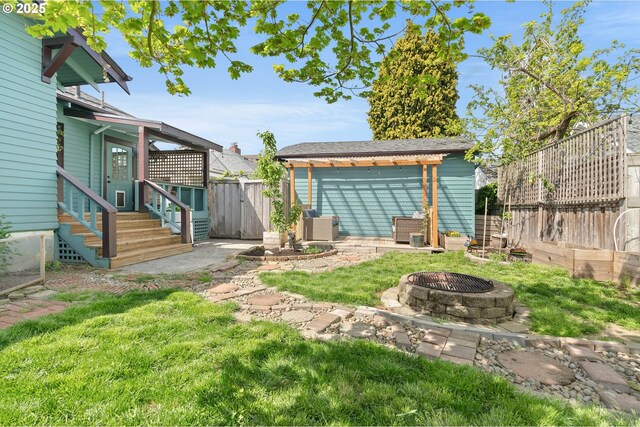 4134 N Concord Ave, Portland, OR 97217 - view of yard featuring a fire pit, a fenced backyard, and entry steps