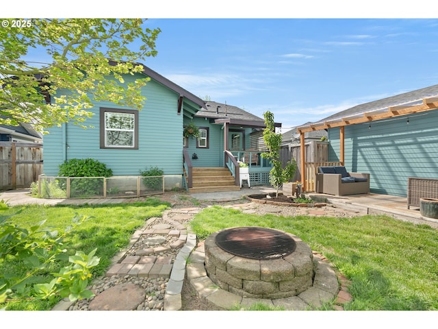 view of front of property featuring a patio, fence, a fire pit, and a front yard