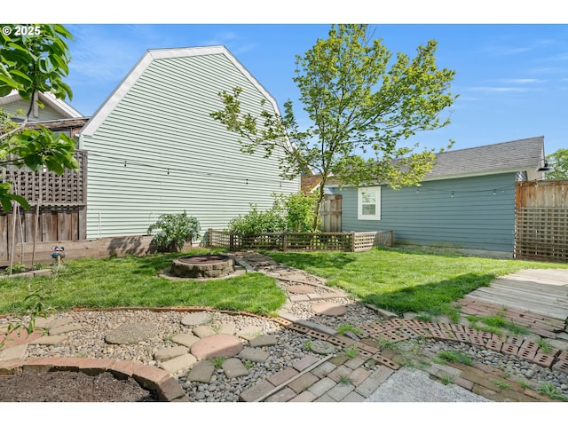 view of yard with fence and an outdoor fire pit