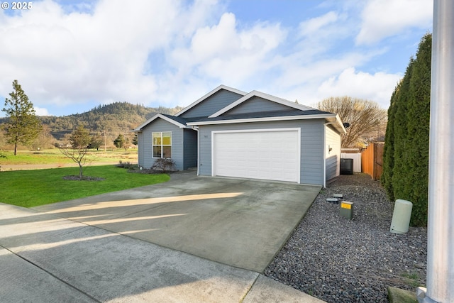 view of front of house featuring a mountain view, a front lawn, and a garage