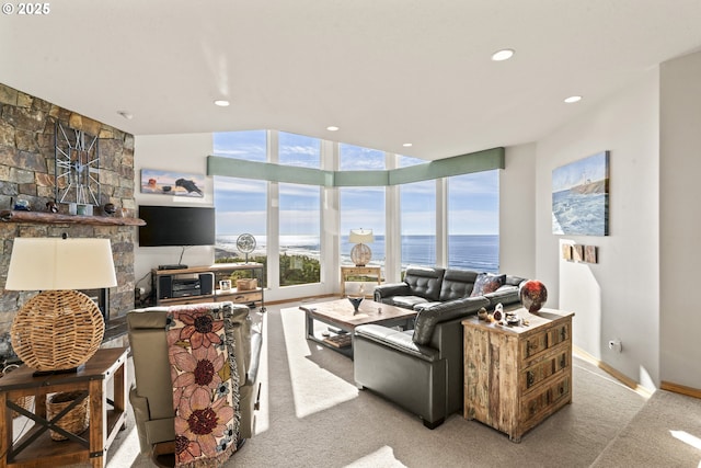 living room featuring a stone fireplace and light carpet