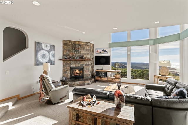 carpeted living room with a stone fireplace