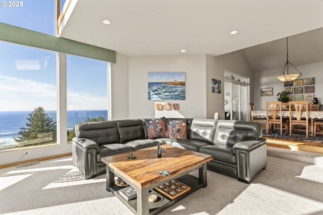 living room featuring carpet flooring, vaulted ceiling, and a water view