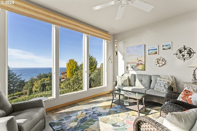 living room with ceiling fan and a water view