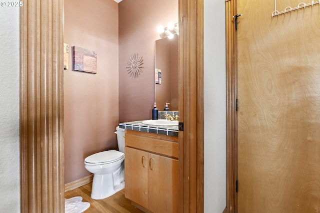 bathroom featuring vanity, hardwood / wood-style floors, and toilet