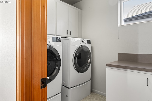 washroom with separate washer and dryer and cabinets