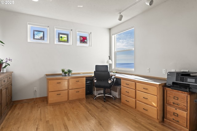 office area featuring rail lighting and light hardwood / wood-style floors