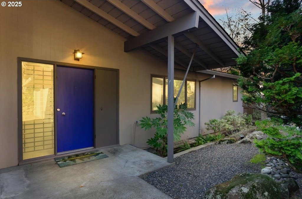 exterior entry at dusk with a patio area