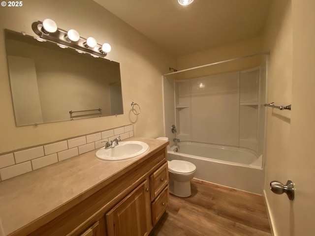 full bathroom with hardwood / wood-style flooring, bathing tub / shower combination, vanity, and toilet