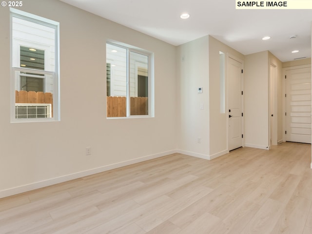 empty room with recessed lighting, wood finished floors, and baseboards