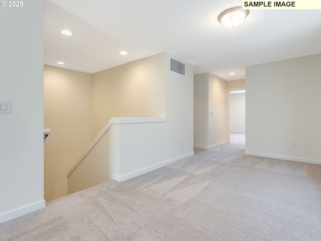 carpeted empty room featuring baseboards, visible vents, and recessed lighting