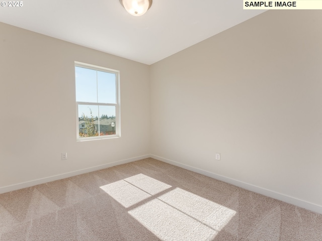 carpeted spare room featuring baseboards