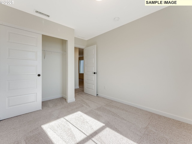 unfurnished bedroom featuring carpet floors, a closet, visible vents, and baseboards