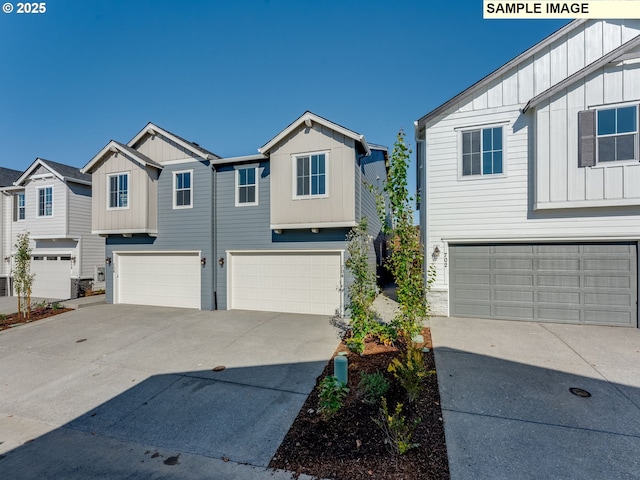 view of front of home featuring an attached garage, driveway, a residential view, and board and batten siding