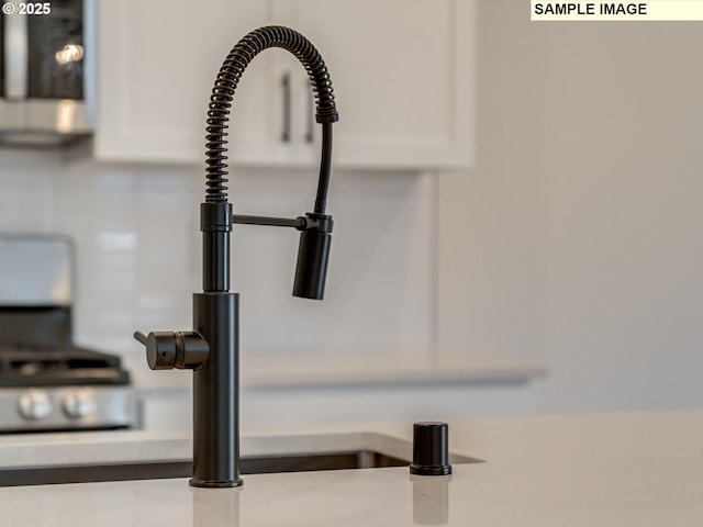 room details featuring light countertops, a sink, and white cabinetry