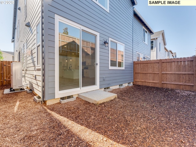 back of property featuring crawl space and fence