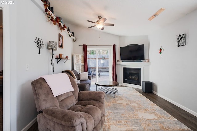 living room with ceiling fan, lofted ceiling, and dark hardwood / wood-style flooring