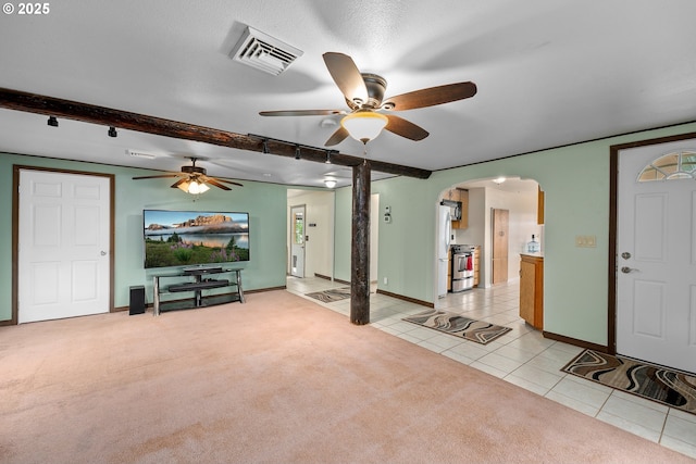 10 SE Kegler Ave, Winston, OR 97496 - living room featuring arched walkways, ceiling fan, light tile patterned floors, light colored carpet, and baseboards