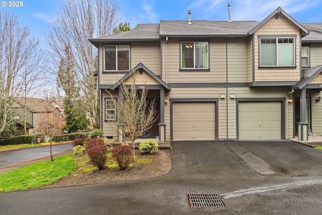 view of property featuring an attached garage, driveway, and a shingled roof