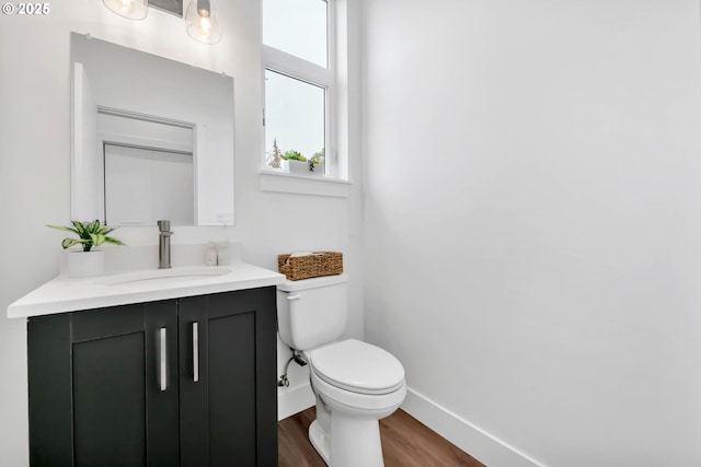 bathroom featuring vanity, wood-type flooring, and toilet