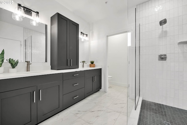 bathroom featuring vanity, toilet, and a tile shower