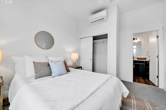 carpeted bedroom featuring a wall unit AC, ensuite bathroom, and a closet