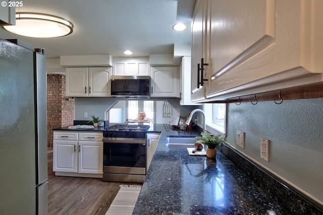kitchen with a sink, white cabinetry, a wealth of natural light, and stainless steel appliances