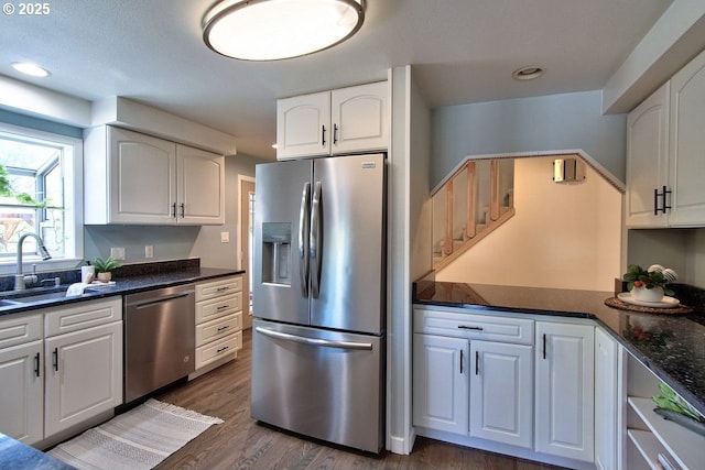 kitchen featuring appliances with stainless steel finishes, a sink, white cabinets, dark wood-style floors, and recessed lighting