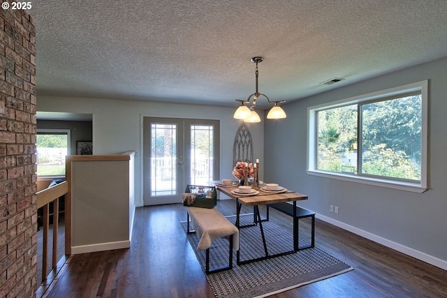 dining area with a chandelier, visible vents, a healthy amount of sunlight, and dark wood finished floors