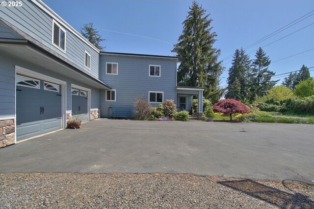 view of home's exterior featuring driveway and stone siding