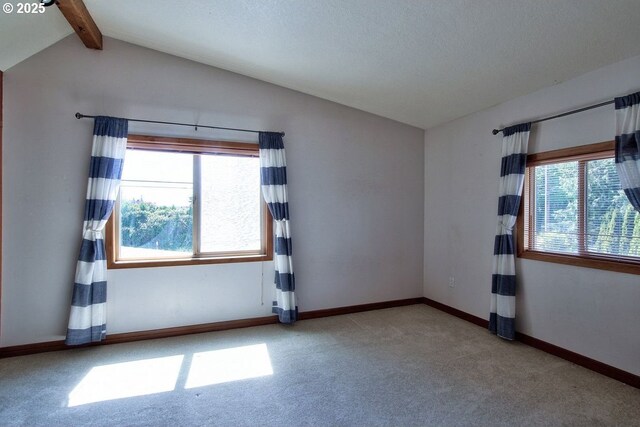 carpeted empty room featuring baseboards and vaulted ceiling with beams