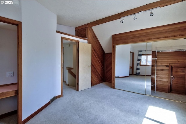 carpeted empty room with wood walls