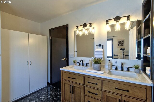 full bath with double vanity, a sink, and marble finish floor