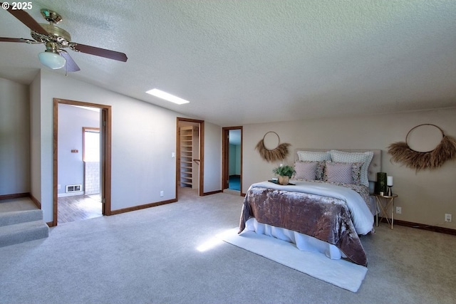 bedroom with carpet floors, lofted ceiling, a textured ceiling, and visible vents