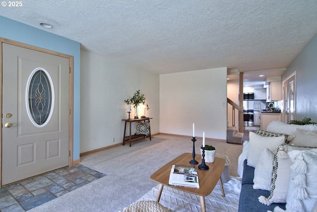 living room featuring baseboards, a textured ceiling, stairs, and light carpet