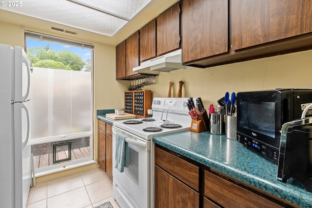 1659 NW Bridgeway Ln, Beaverton, OR 97006 - kitchen featuring white appliances, under cabinet range hood, and light tile patterned flooring