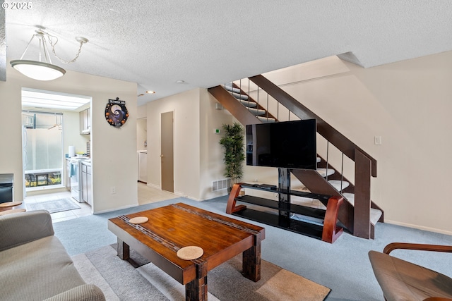1659 NW Bridgeway Ln, Beaverton, OR 97006 - carpeted living room with stairway, washing machine and dryer, a textured ceiling, and baseboards