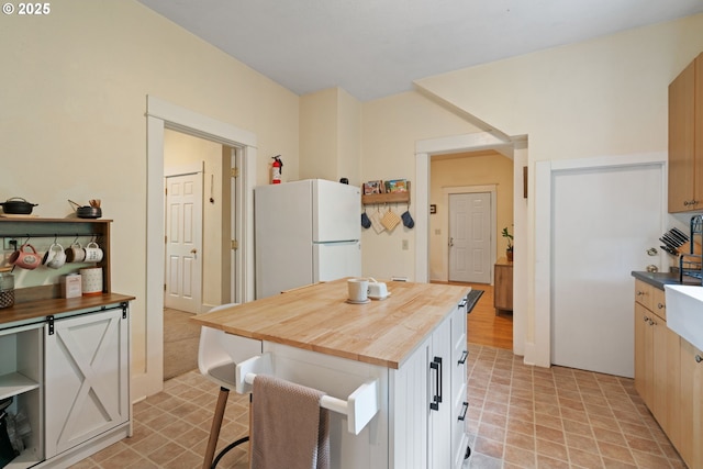 11151117 N Beech St, Portland, OR 97227 - kitchen with freestanding refrigerator, wood counters, a breakfast bar, and a kitchen island